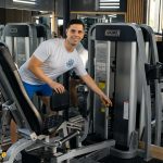 Cosmin Papadopol, instructor de fitness, reglând un aparat într-o sală de fitness din Constanța
