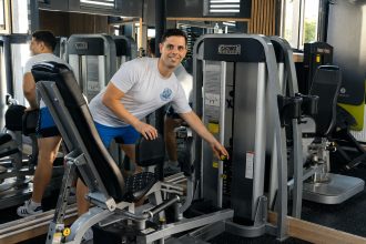 Cosmin Papadopol, instructor de fitness, reglând un aparat într-o sală de fitness din Constanța